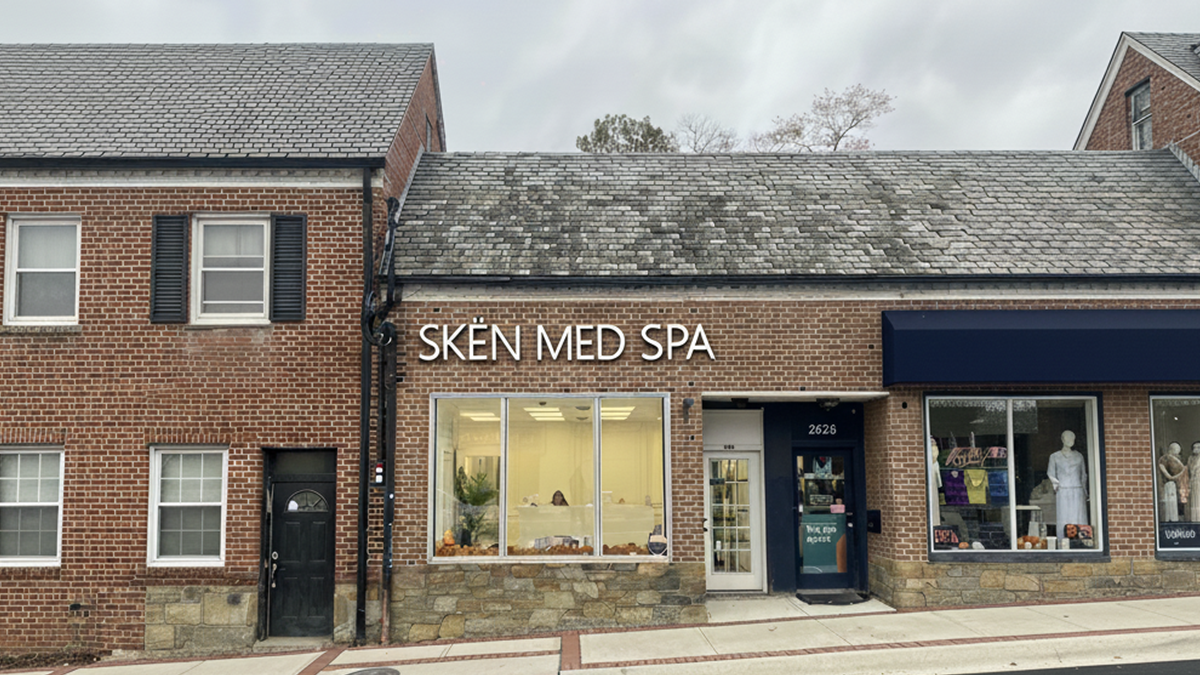 Brick storefront with Skin Med Spa signage, large display windows, and attached residential building